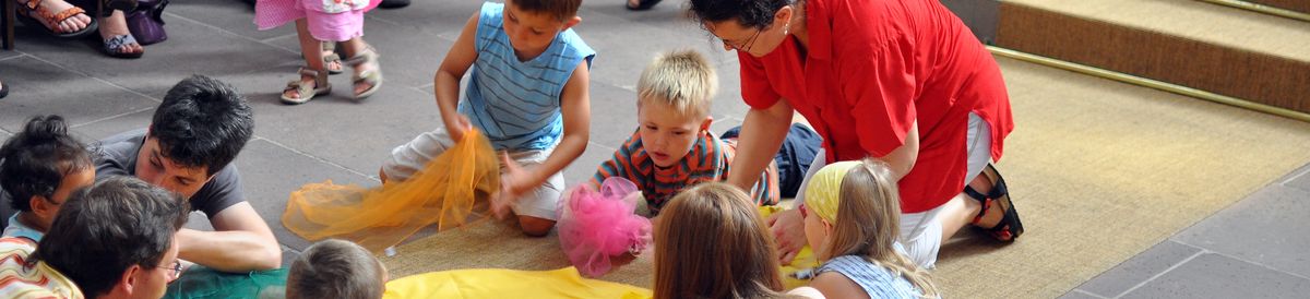 Kinder liegen auf dem Boden und schauen sich etwas an