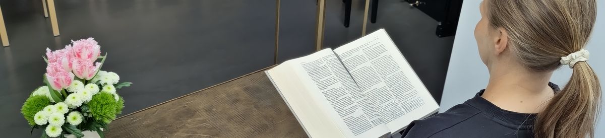 Person vor Kanzel mit Bibel in der Hand